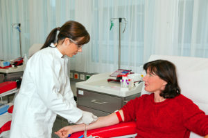 Phlebotomist drawing blood from a patient
